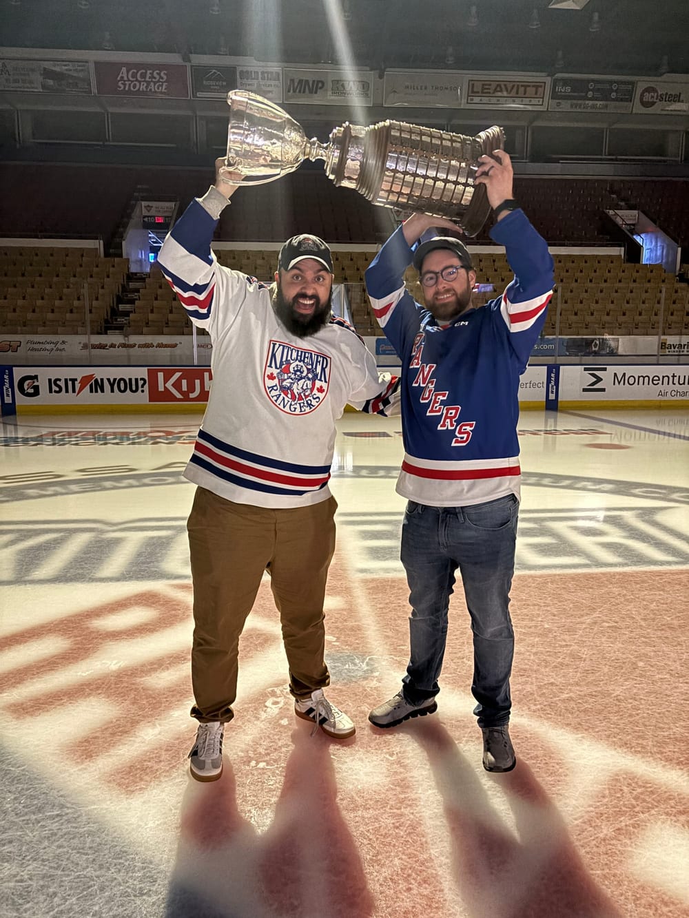 Justin and Andrew standing center ice at The Aud, hoisting the J. Ross Robertson Cup